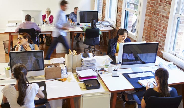 Aerial view of busy office with co-workers working on computers.