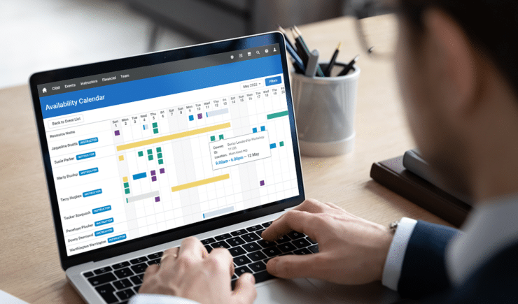 Training professional looking at the Availability Calendar feature of Administrate on their laptop.