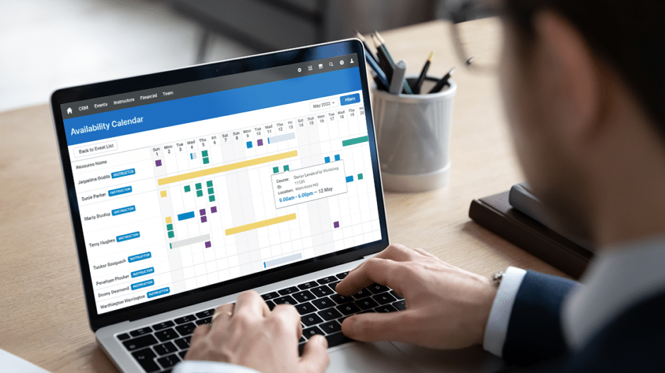 Training professional looking at the Availability Calendar feature of Administrate on their laptop.