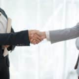 business professionals shaking hands in agreement.