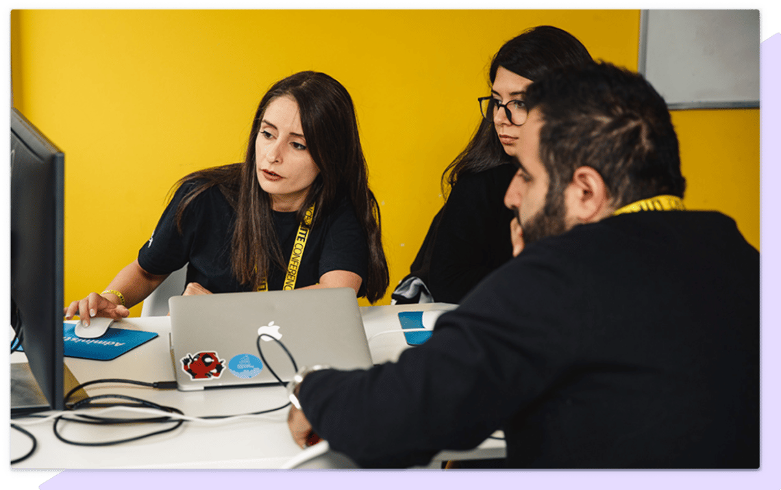 Group of women and a man looking at a monitor during a working session.