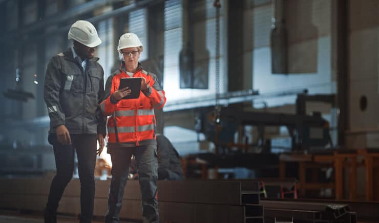 Industry professionals recording progress of tasks on a tablet.