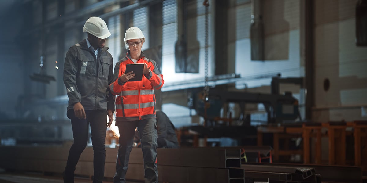 Industry professionals recording progress of tasks on a tablet.