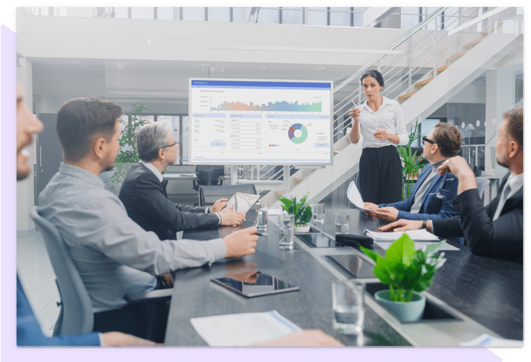 Training professionals of various ages collaborate and review a monitor displaying a report and graphs showing training performance.