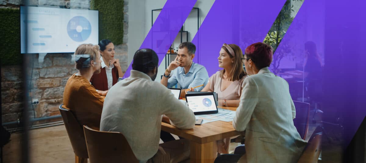 Training team consults over a chart and graph in a conference room.