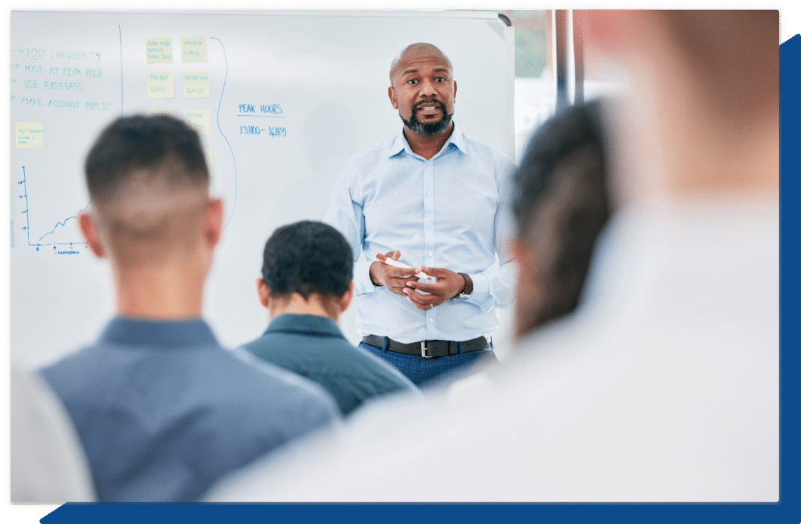 A male instructor leads a corporate classroom training session