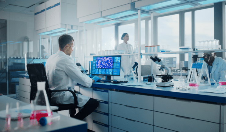 Medical professionals working on a computer in a lab.