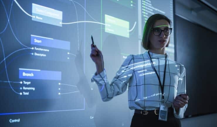 An image of an instructor pointing to a diagram while leading a class.