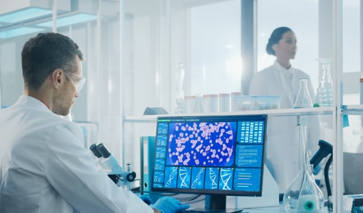 Medical professionals working on a computer in a lab.