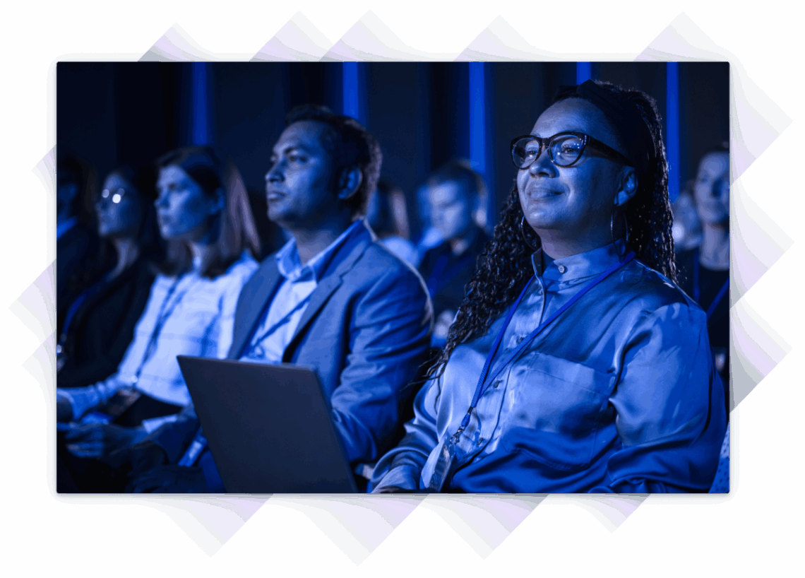 Group of professionals attentively watching a presentation at a training event.