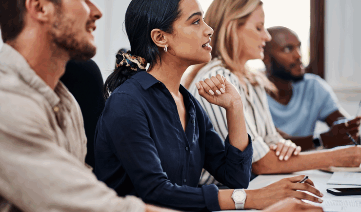 People in a corporate training session smiling and engaging with instructor led training.