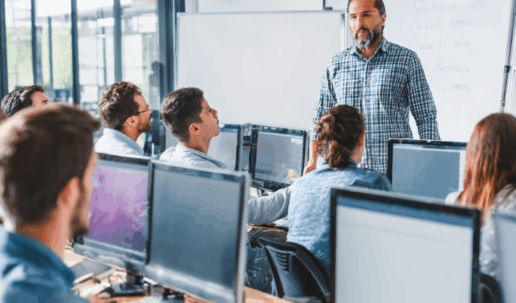 Instructor leads a group of corporate learners in an ILT session